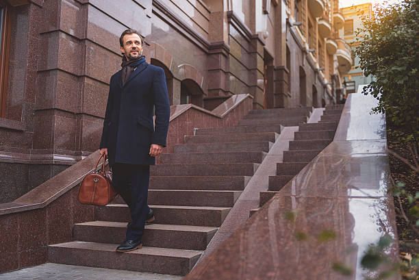 istock Successful businessman on staircase with suitcase 627345404