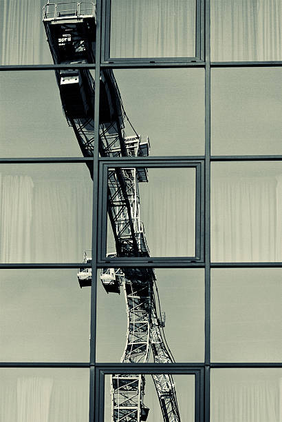 Crane in reflection of the sky in the glass windows stock photo