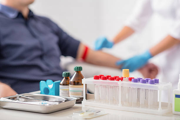 Man getting blood test preparation in clinic Doctor preparing patient for blood sampling. Focus on blood test tools on table patient blood management stock pictures, royalty-free photos & images
