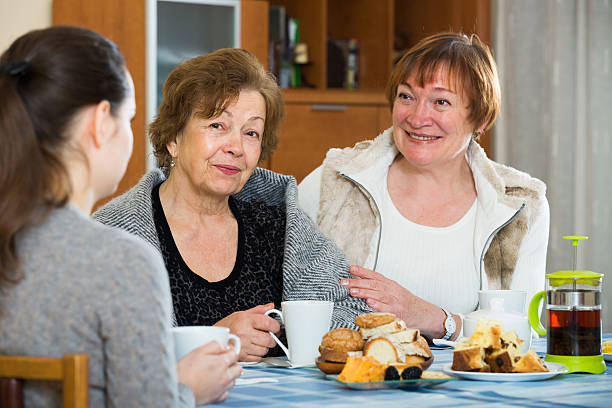 istock Young female and mature women drinking tea and talking 627357520