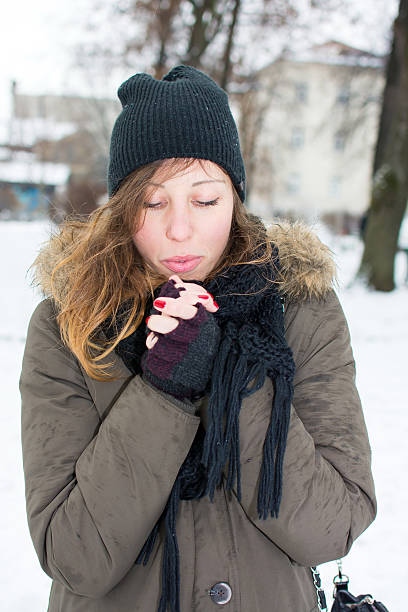 istock woman warming hands in snow covered park 627364146