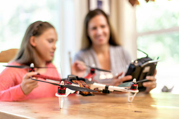istock Mother and daughter looking at a drone quadcopter 627371860