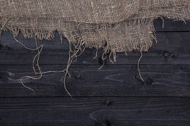 istock Dark wooden table background with burlap 627372060