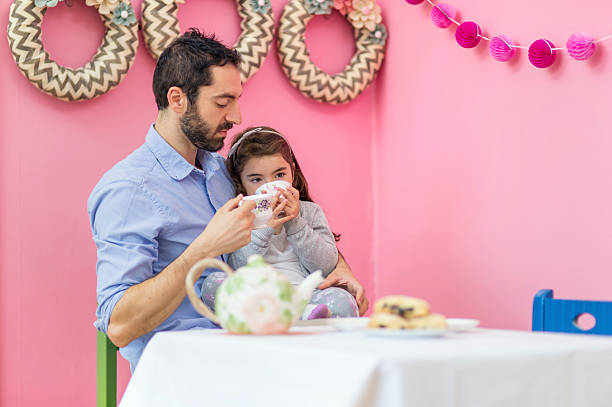 istock Ethnic father holding his daughter on lap drinking tea 627373322