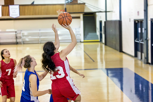 Diverse high school female basketball team playing a game