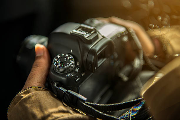 Unrecognizabe person holding a DSLR camera