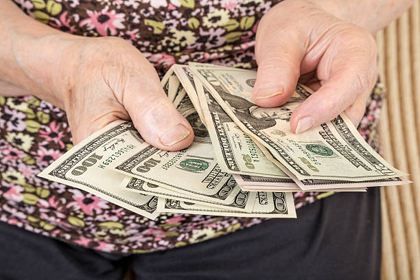 istock Senior woman counting Dollars 627379502