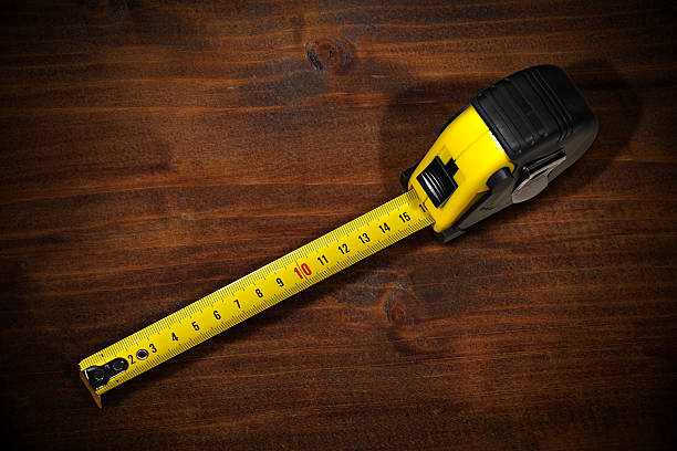 istock Tape Measure on a Wooden Work Table 627380028