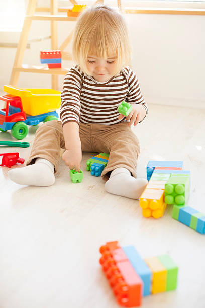 istock Little child playing with colorful plastic blocks 627380042