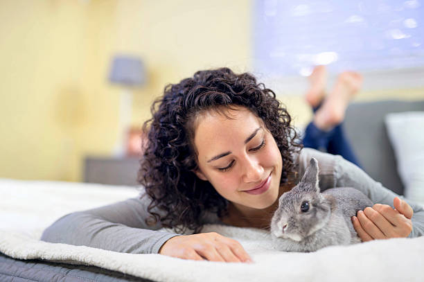 istock Young adult Hispanic female laying down with her bunny rabbit 627380142