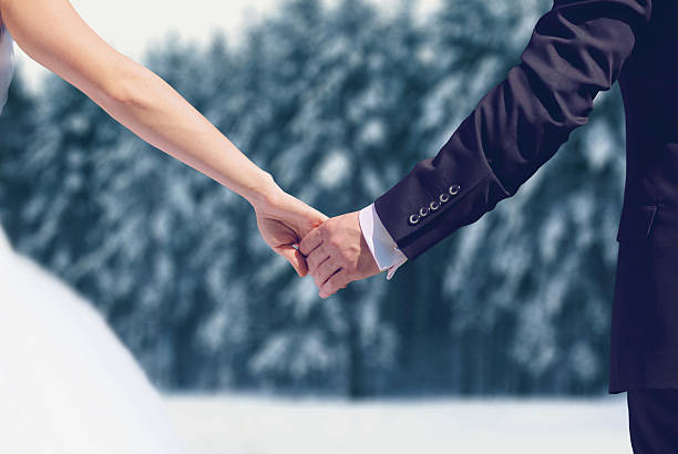 Wedding couple, bride and groom in winter holding hands together stock photo