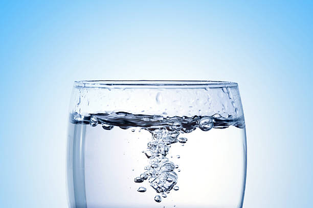 istock pouring water into a glass closeup with copy space 627390890