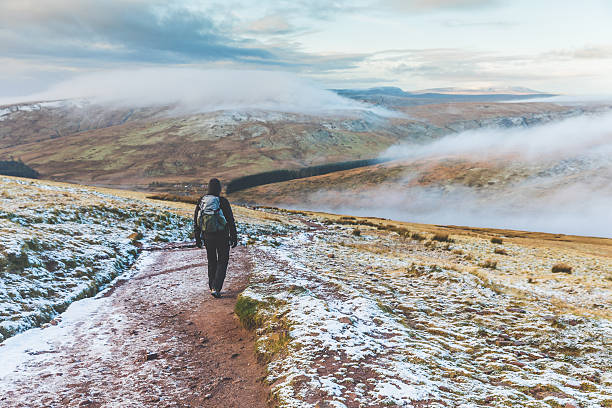 mann läuft im winter auf verschneiten hügeln - brecon beacons nationalpark stock-fotos und bilder