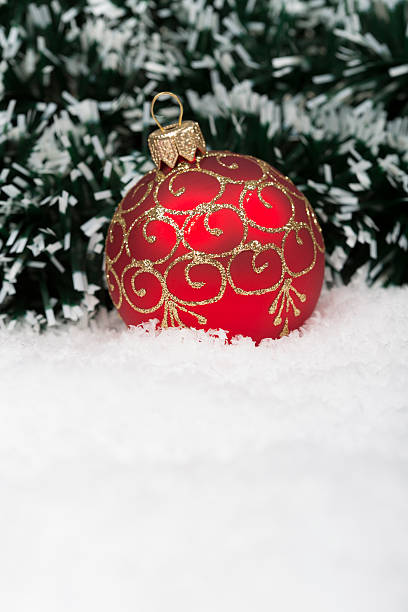 istock Christmas background with a red ornament, gift boxes on snow 627398848