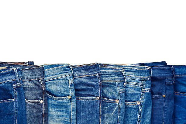 Row of fashion different jeans isolated on white. stock photo