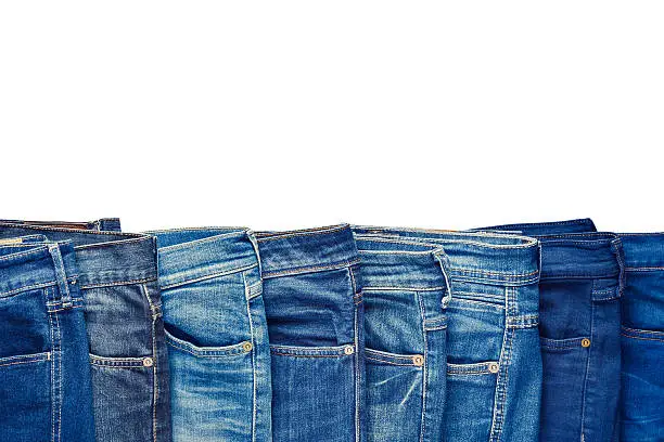 Photo of Row of fashion different jeans isolated on white.