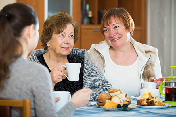 istock Senior women talking with girl while tea drinking 627401320