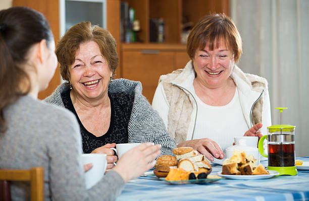 istock Senior women talking with girl while tea drinking 627401492