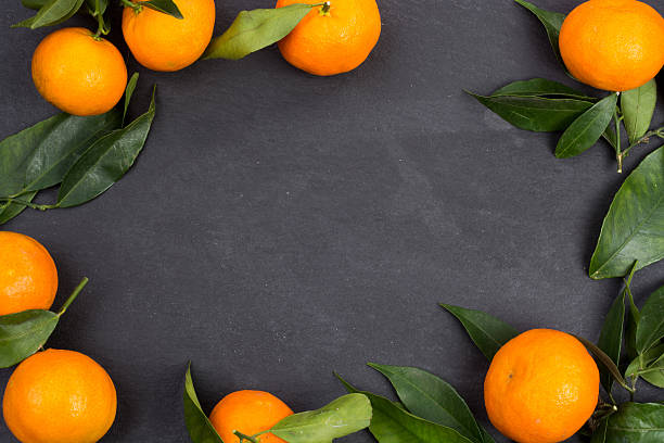 istock Tangerine fruits on dark table 627401810