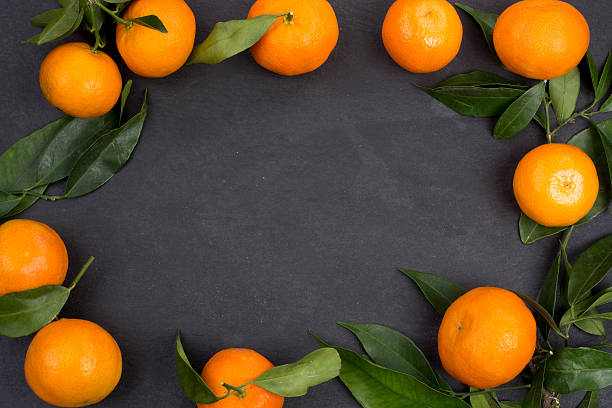 istock Tangerine fruits on dark table 627401952