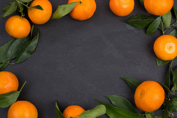 istock Tangerine fruits on dark table 627402068