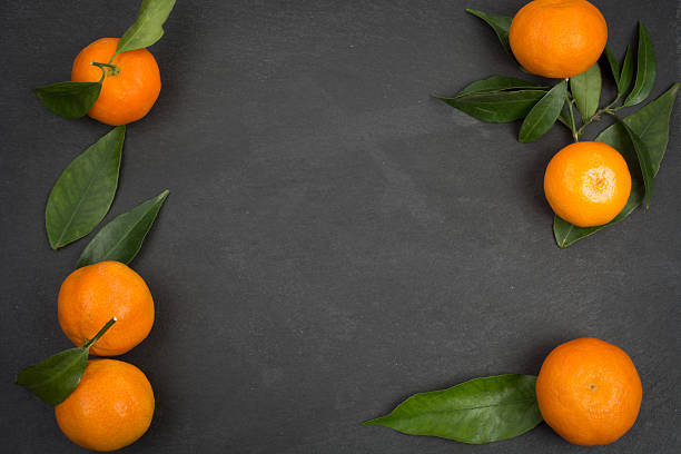 istock Tangerine fruits on dark table 627402128