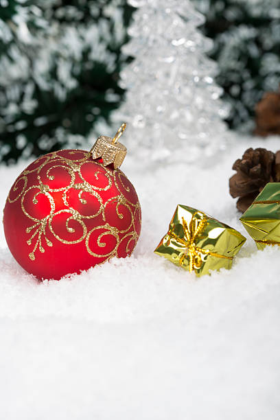 istock Christmas background with a red ornament, gift boxes on snow 627415076