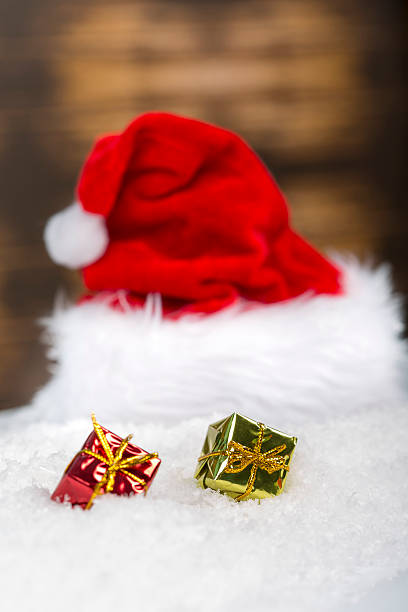 istock Santa Claus cap hat laying on snow with christmas ornaments 627415536