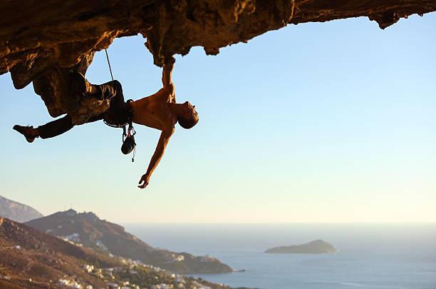 istock Young man climbing on roof of cave 627415968