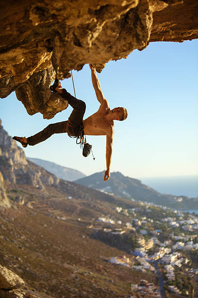 istock Young man climbing on roof of cave 627417270