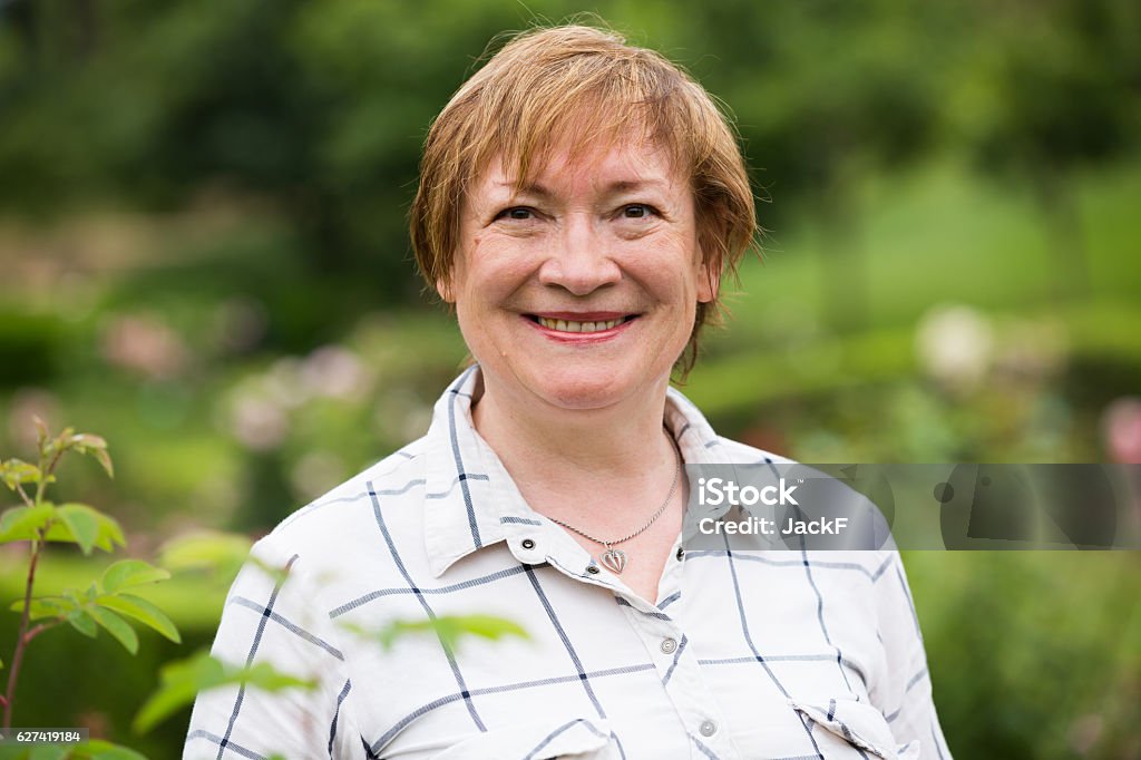 mature woman portrait closeup on smiling senior woman outdoors on sunny summer day 60-69 Years Stock Photo