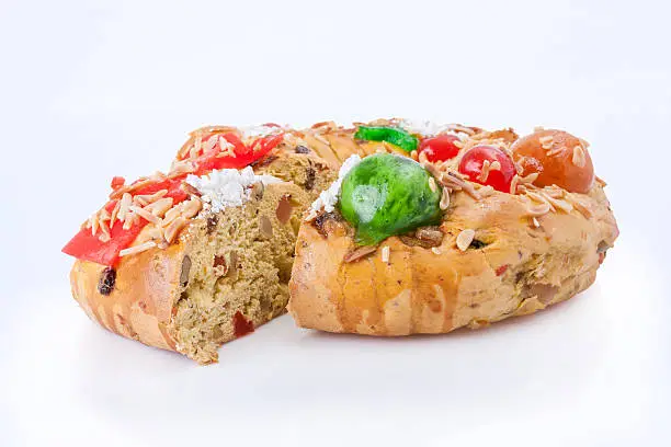 Sliced Bolo Rei (King Cake), the traditional Portuguese Christmas cake, made with candied fruits, isolated on white background