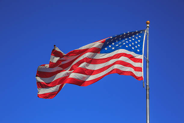istock American flag waving on the wind on blue sky background 627427186