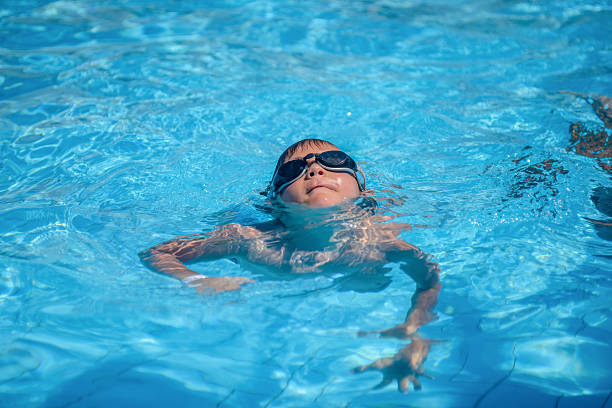 istock Little boy floating in a swimming pool 627430198