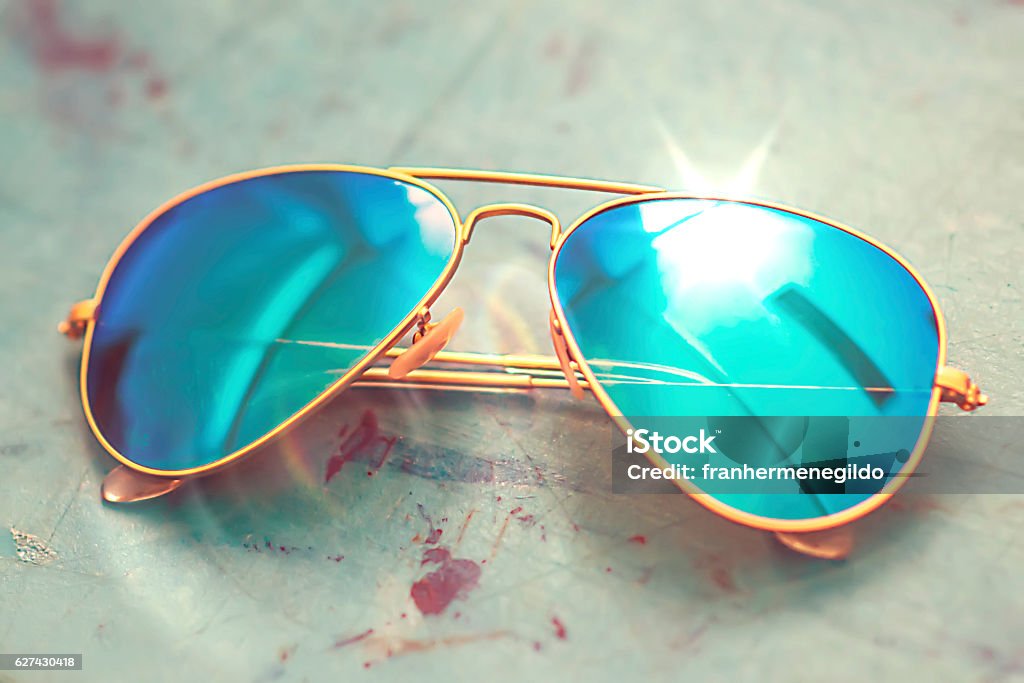 shining blue sunglasses Stylish blue sunglasses isolated on gray background. Refraction Stock Photo