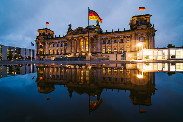 Reichstag, Berlin The Reichstag building in Berlin, Germany, and its reflection at night german flag stock pictures, royalty-free photos & images