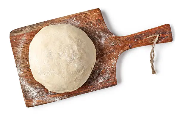 Photo of fresh raw dough on wooden board