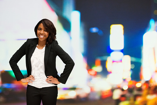 Smiling businesswoman standing outdoors at night