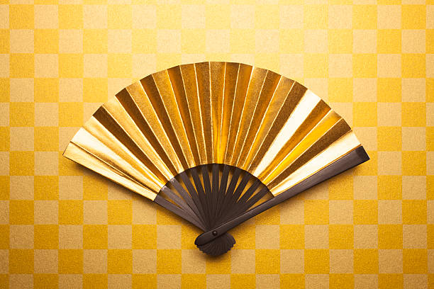 Gold folding fan Gold folding fan for backgrounds. folding fan stock pictures, royalty-free photos & images