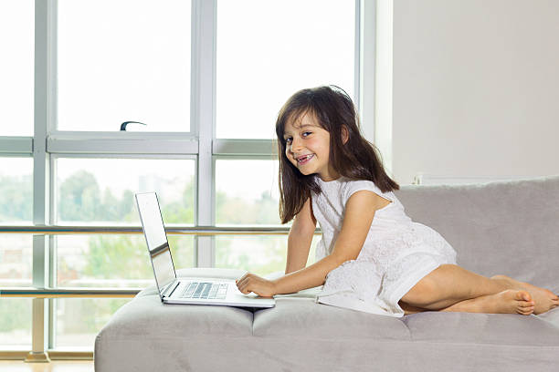 istock Little girl using computer in front of windows 627473570