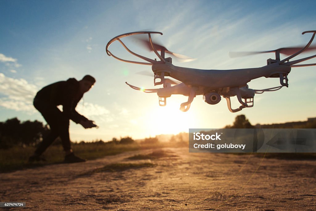 Pilot running drone at sunset light, free space Drone Toy Adult Helicopter Electronics Technology Innovation Aeromodelling Fun Leisure Concept Drone Stock Photo