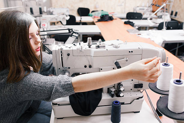 istock Alone seamstress overworking at garment factory 627475012