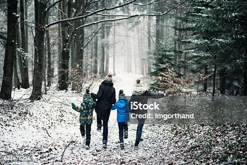 istock Happy family running in beautiful winter forest 627476256