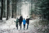 Happy family running in beautiful winter forest