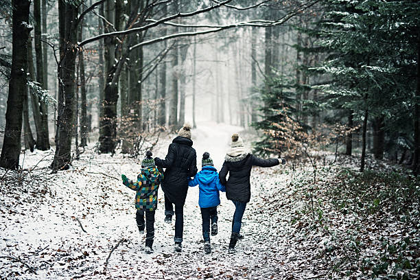 szczęśliwa rodzina biegająca w pięknym zimowym lesie - family winter walking fun zdjęcia i obrazy z banku zdjęć