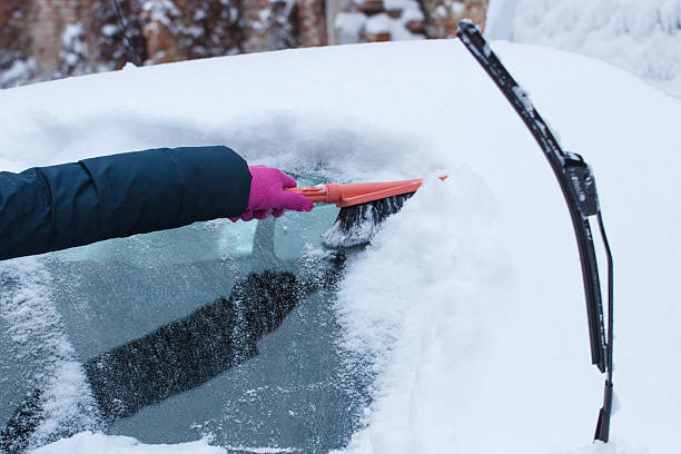 istock Hand of woman using brush and remove snow from car 627476306