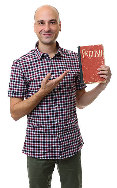 istock learning english. Smiling man holds a textbook 627477860
