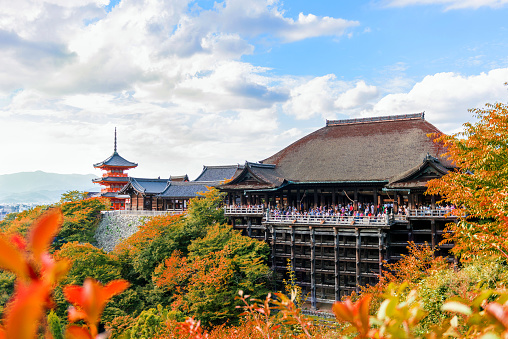 kyoto, Japan - September 10, 2016: Visitors on the stage enjoy beautiful view of fall foliage surrounding Kiyomizu-dera Temple and Kyoto city view in the morning.