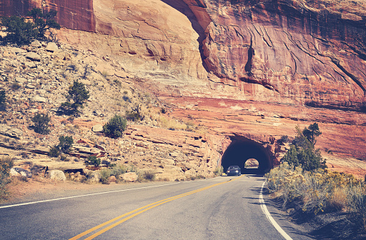 Vintage toned road through rock tunnel, Colorado National Monument, Colorado, USA