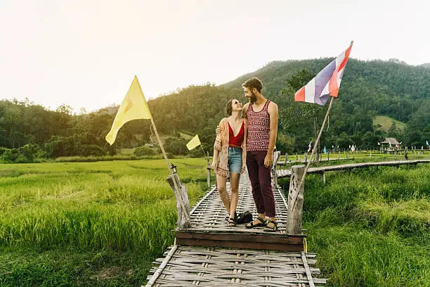 Photo of Couple on bamboo bridge in rice field